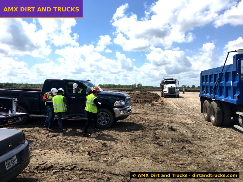 AMX Dirt and Trucks dispatch team coordinating jobsite logistics with crew and dump trucks in Houston, Texas