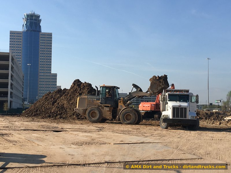 Wheel loader loading dump truck near Williams Tower in Uptown Houston Galleria district