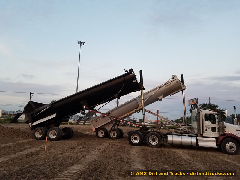End dump trailers dumping fill dirt at dusk on Houston construction site