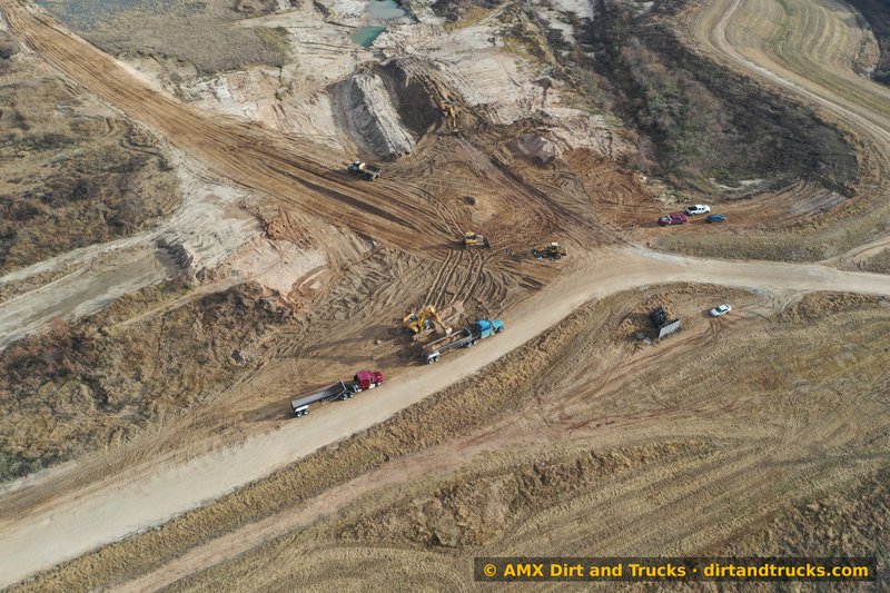 Drone view of end dump trailer being loaded by excavator at Houston dirt pit operation