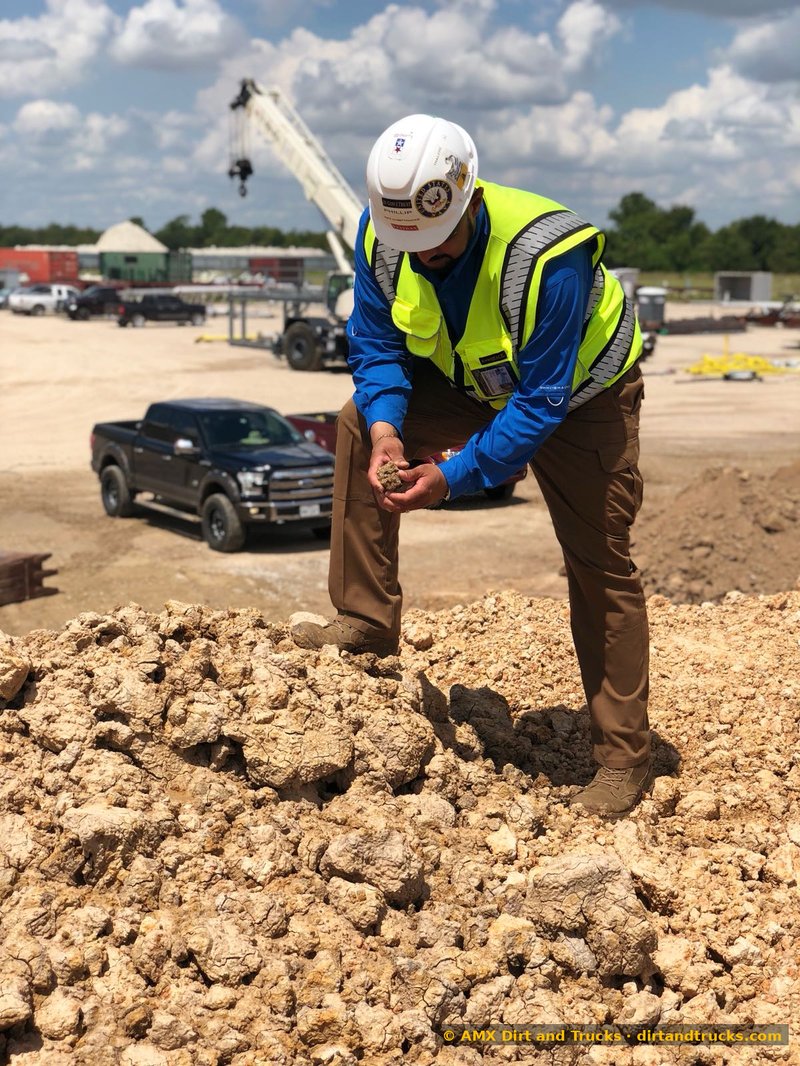 Phillip Anthony, SDVOSB-verified U.S. Navy veteran owner of AMX Dirt and Trucks, inspecting select fill material on Houston jobsite